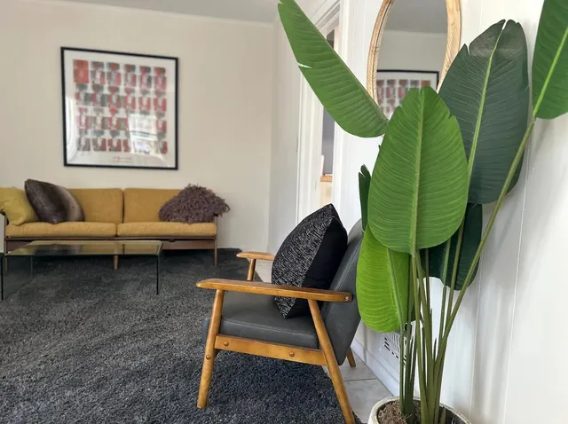 a living room with furniture and a painting on the wall