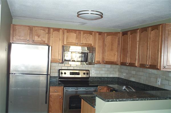 880 Broadway Chelsea, MA 02150 - Photo 5 of 18 a kitchen with a refrigerator a stove a sink and cabinets