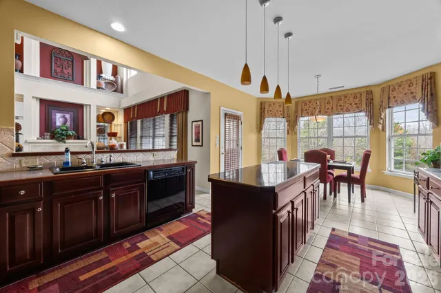 a open kitchen with stainless steel appliances granite countertop a dining table and chairs