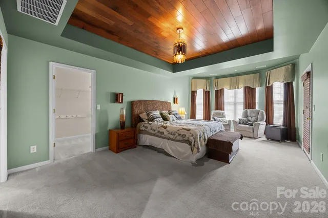 a spacious bedroom with a bed and a chandelier