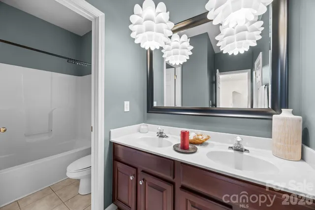 a bathroom with a granite countertop sink a toilet and a mirror