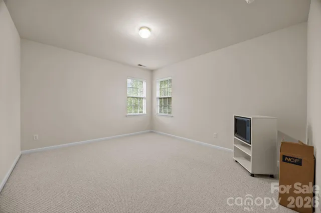 an empty room with windows and cabinet