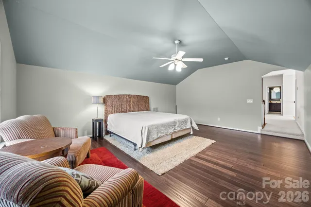 a bedroom with a bed lamps and wooden floor