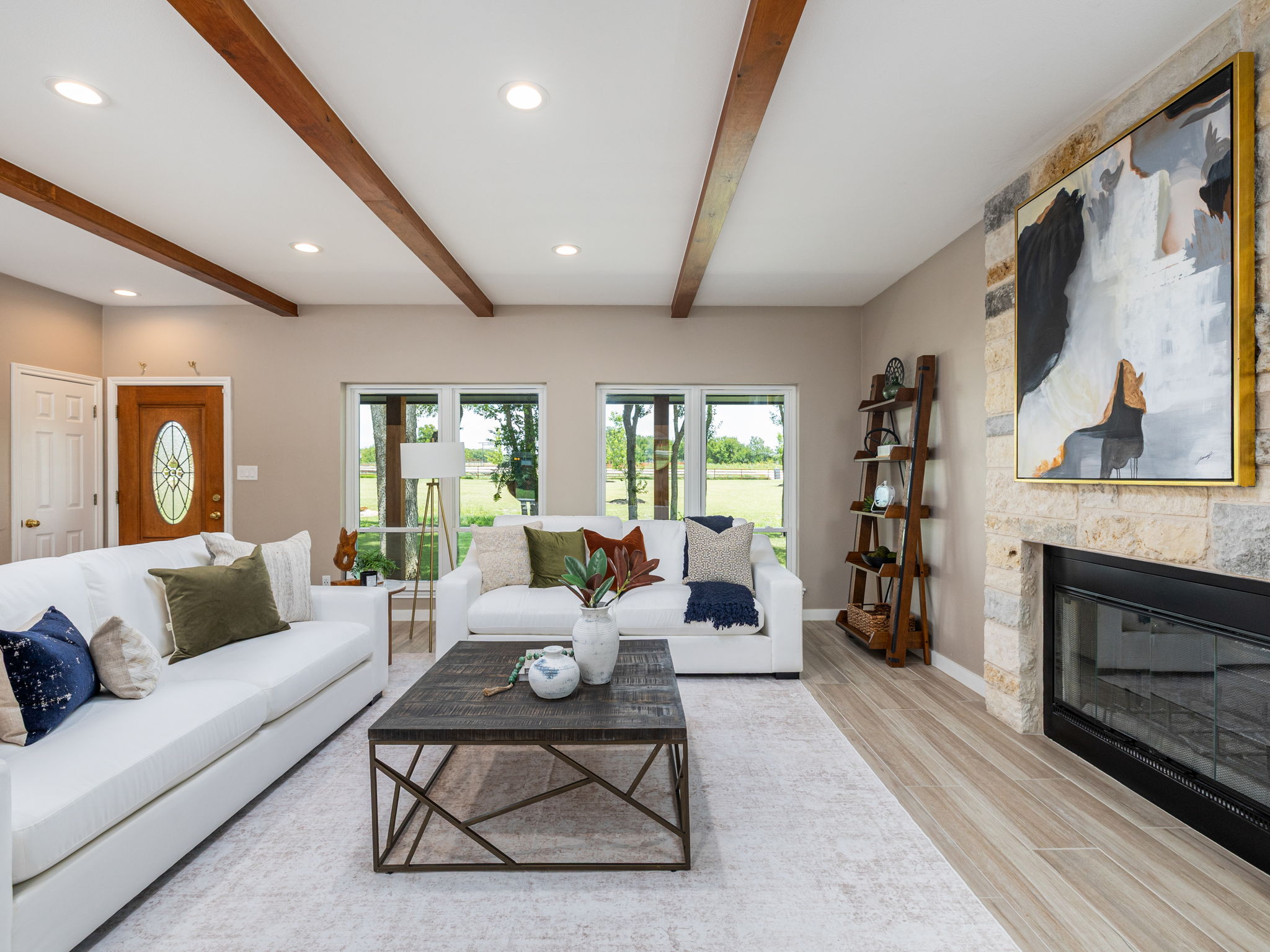 3001 County Road 255 Georgetown, TX 78633 - Photo 8 of 35 Exposed wood beams add architectural interest to this inviting living room, complemented by a stone-clad fireplace.
