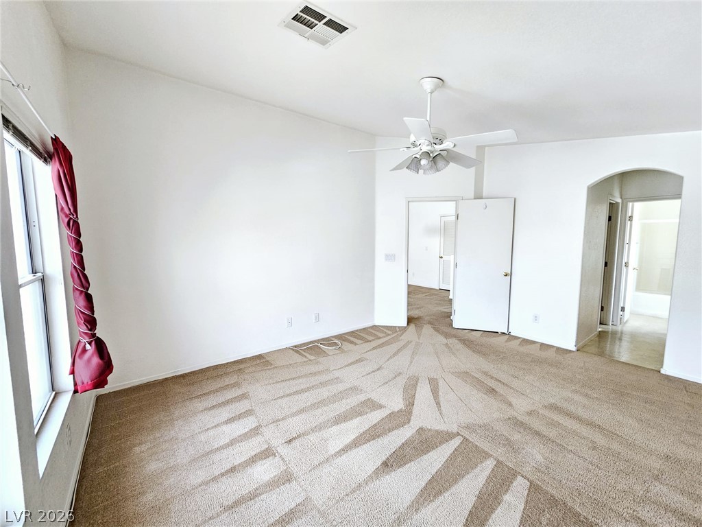 1663 Lefty Garcia Way Henderson, NV 89002 - Photo 5 of 31 Discover comfort in this bedroom featuring a ceiling fan and plush carpet.