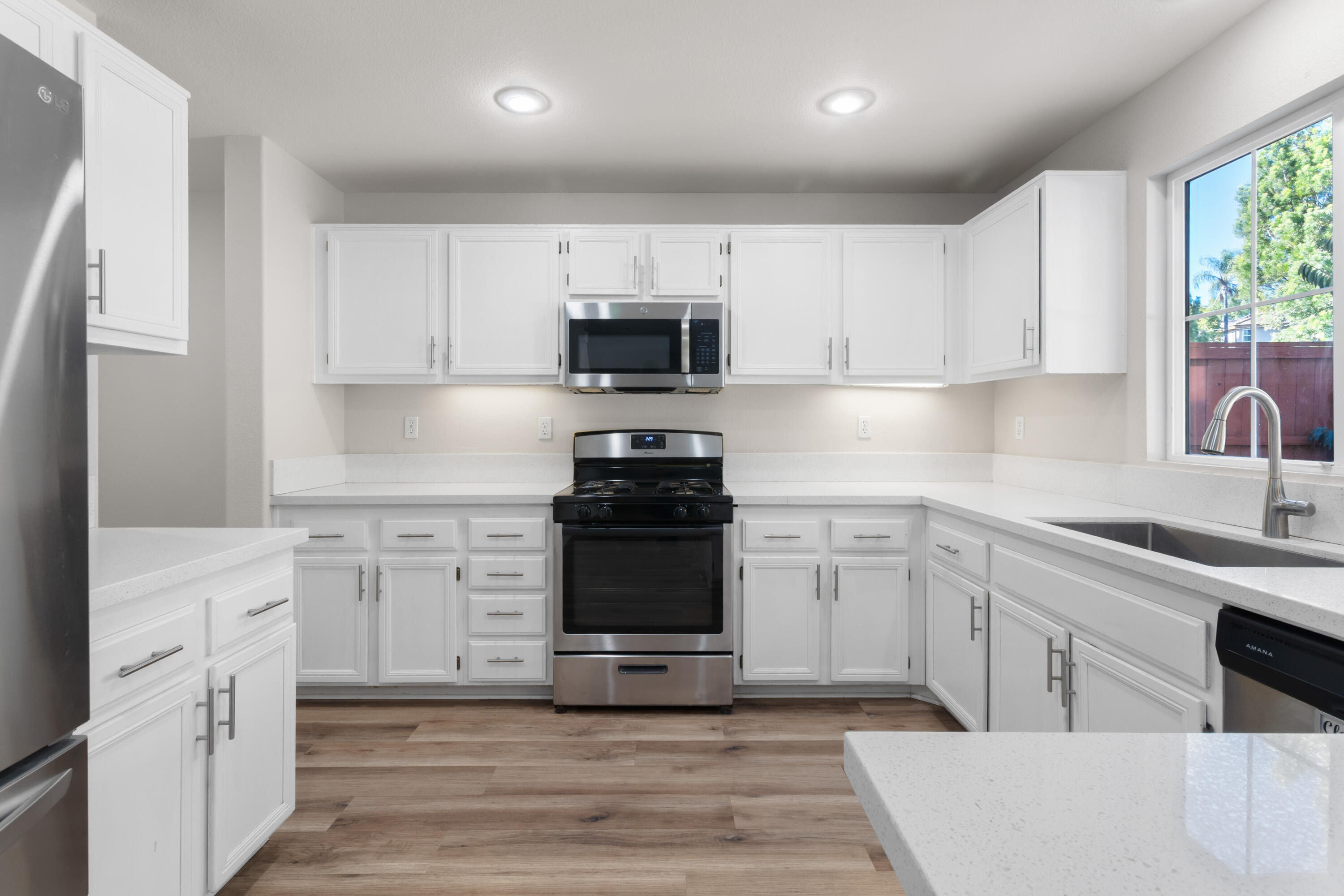 41970 Pacific Grove Way Temecula, CA 92591 - Photo 14 of 54 a kitchen with granite countertop white cabinets and stainless steel appliances