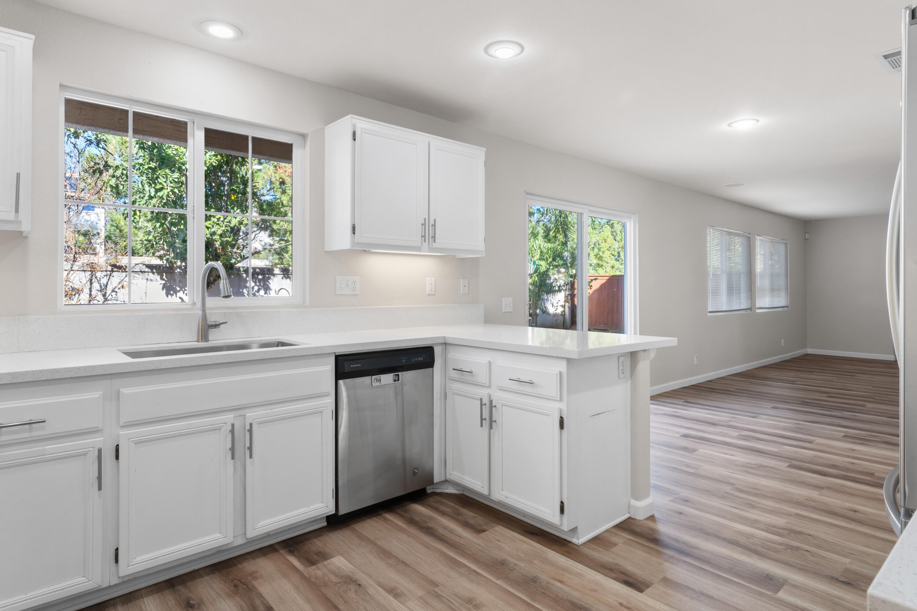 41970 Pacific Grove Way Temecula, CA 92591 - Photo 16 of 54 a kitchen with white cabinets and wooden floors