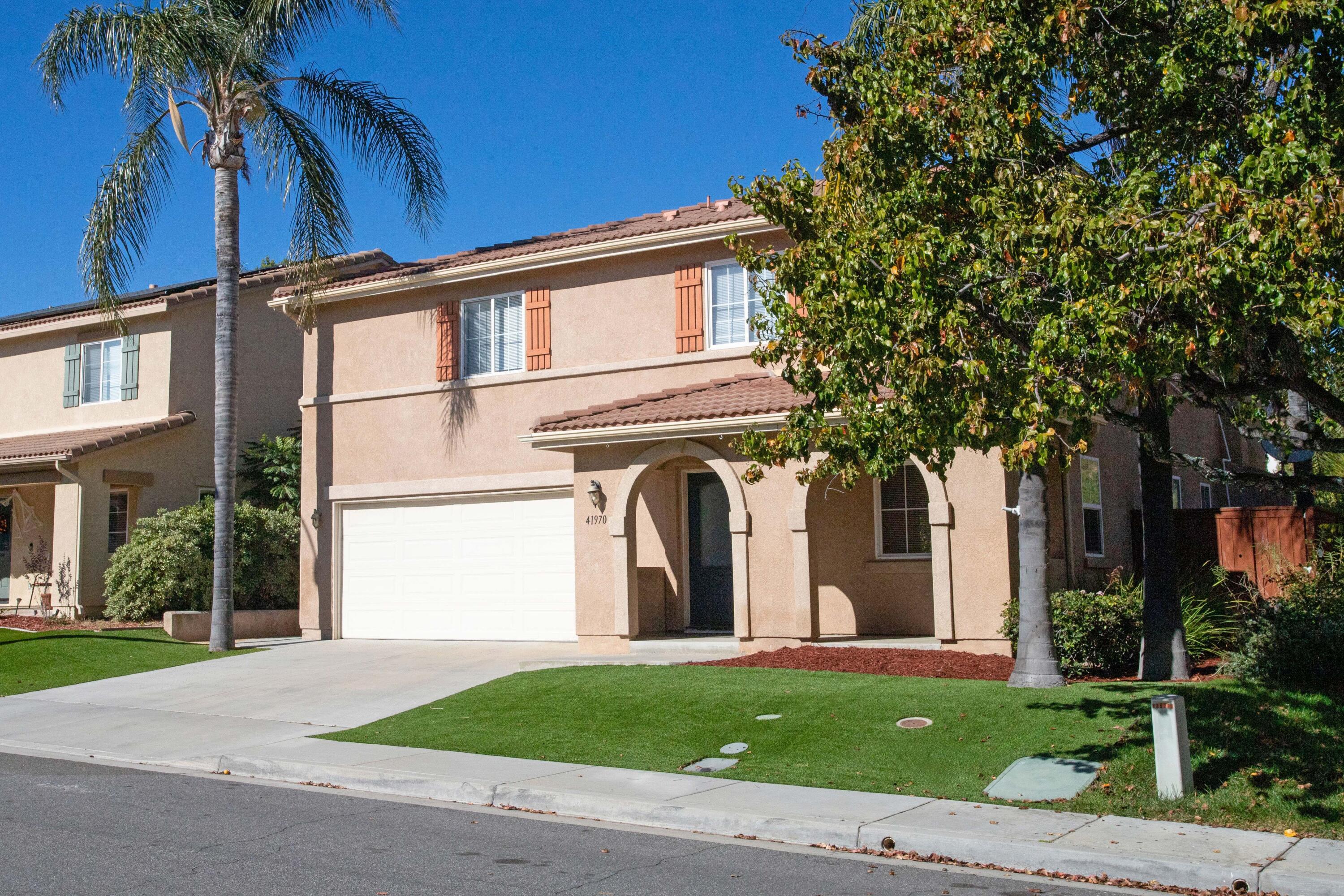 41970 Pacific Grove Way Temecula, CA 92591 - Photo 2 of 54 a front view of a house with a garden and trees