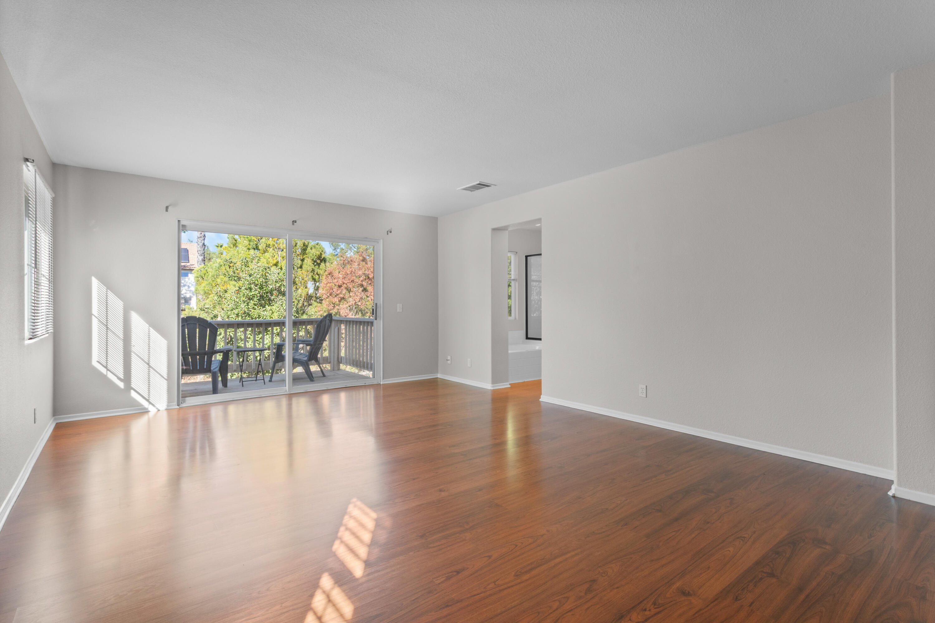 41970 Pacific Grove Way Temecula, CA 92591 - Photo 27 of 54 a view of an empty room with wooden floor and a window