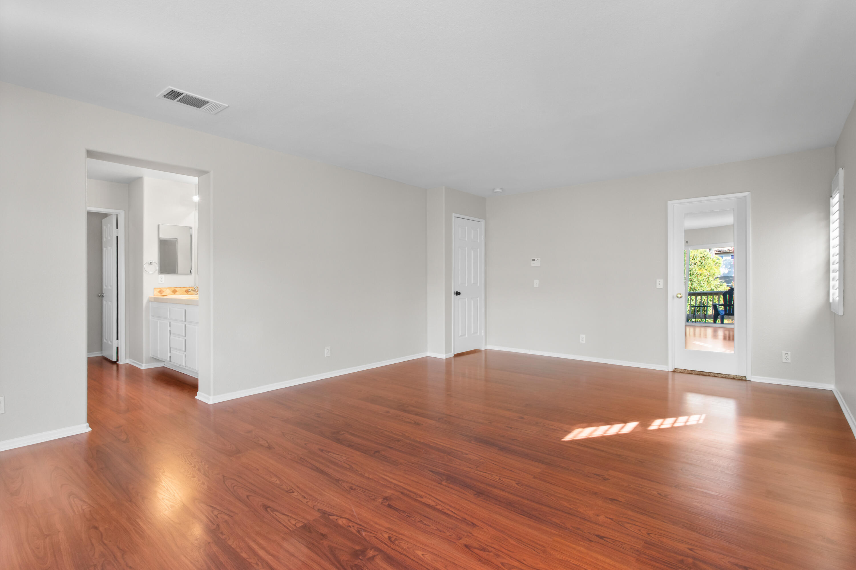 41970 Pacific Grove Way Temecula, CA 92591 - Photo 28 of 54 an empty room with wooden floor and windows