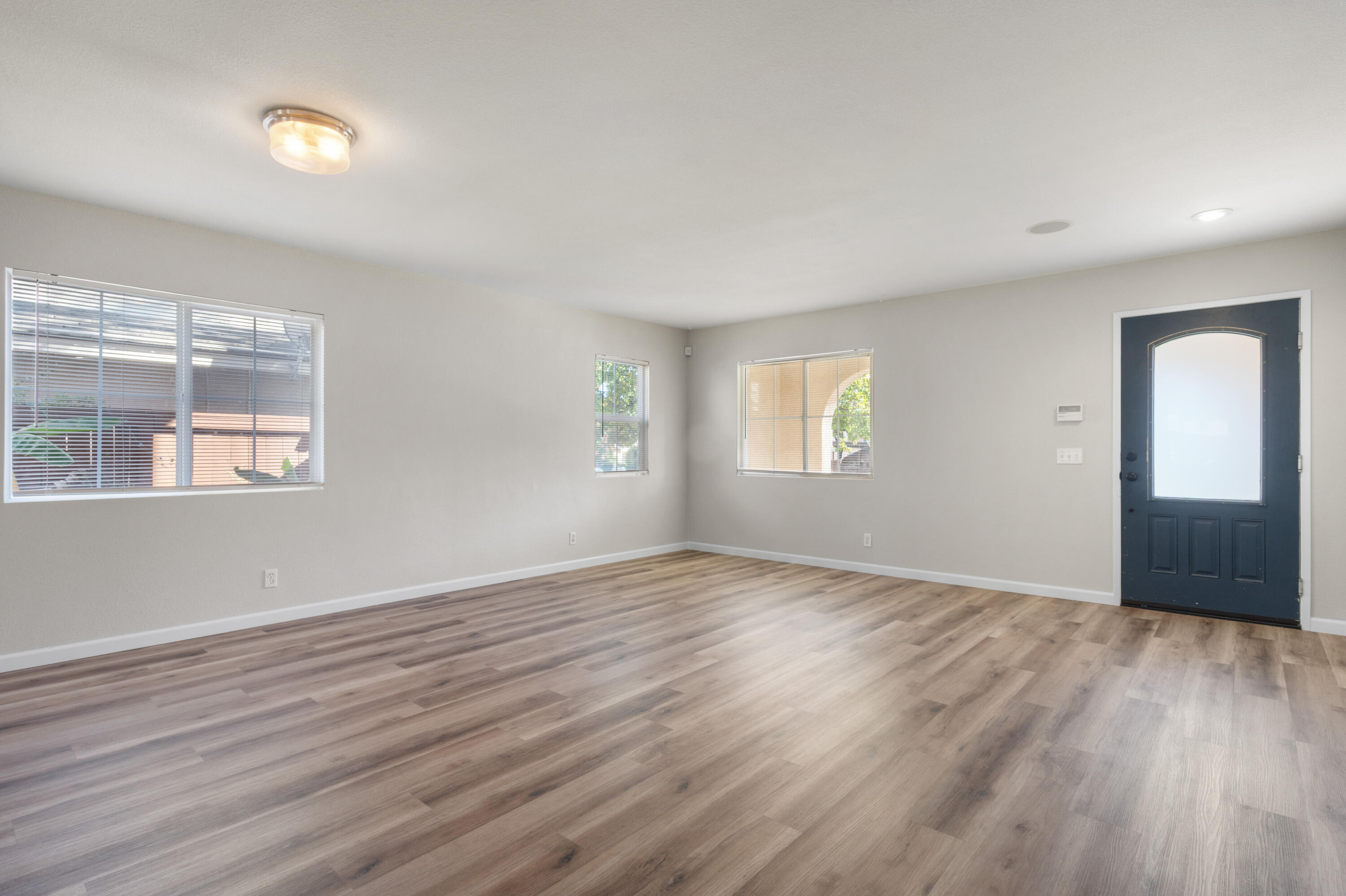 41970 Pacific Grove Way Temecula, CA 92591 - Photo 4 of 54 an empty room with wooden floor and windows