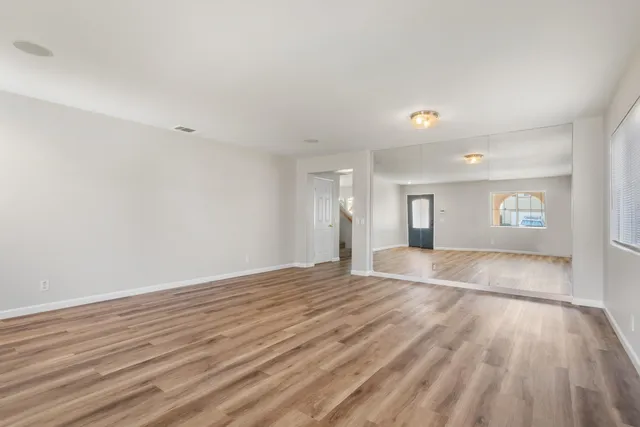 a view of a hallway with wooden floor and staircase