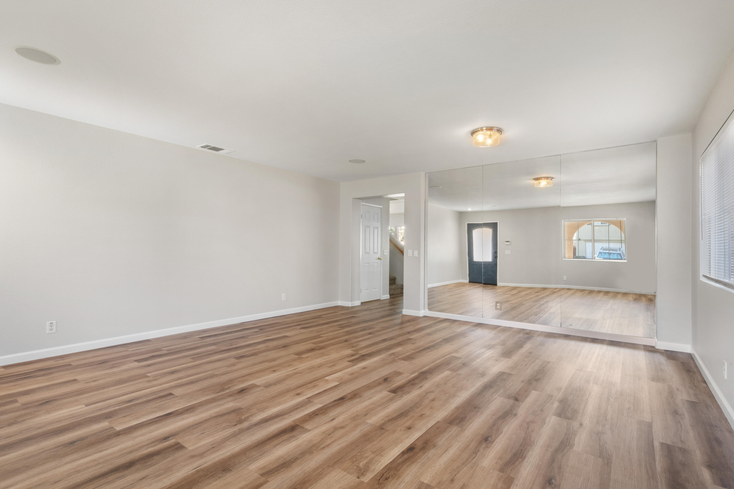 41970 Pacific Grove Way Temecula, CA 92591 - Photo 6 of 54 a view of an empty room with window and wooden floor