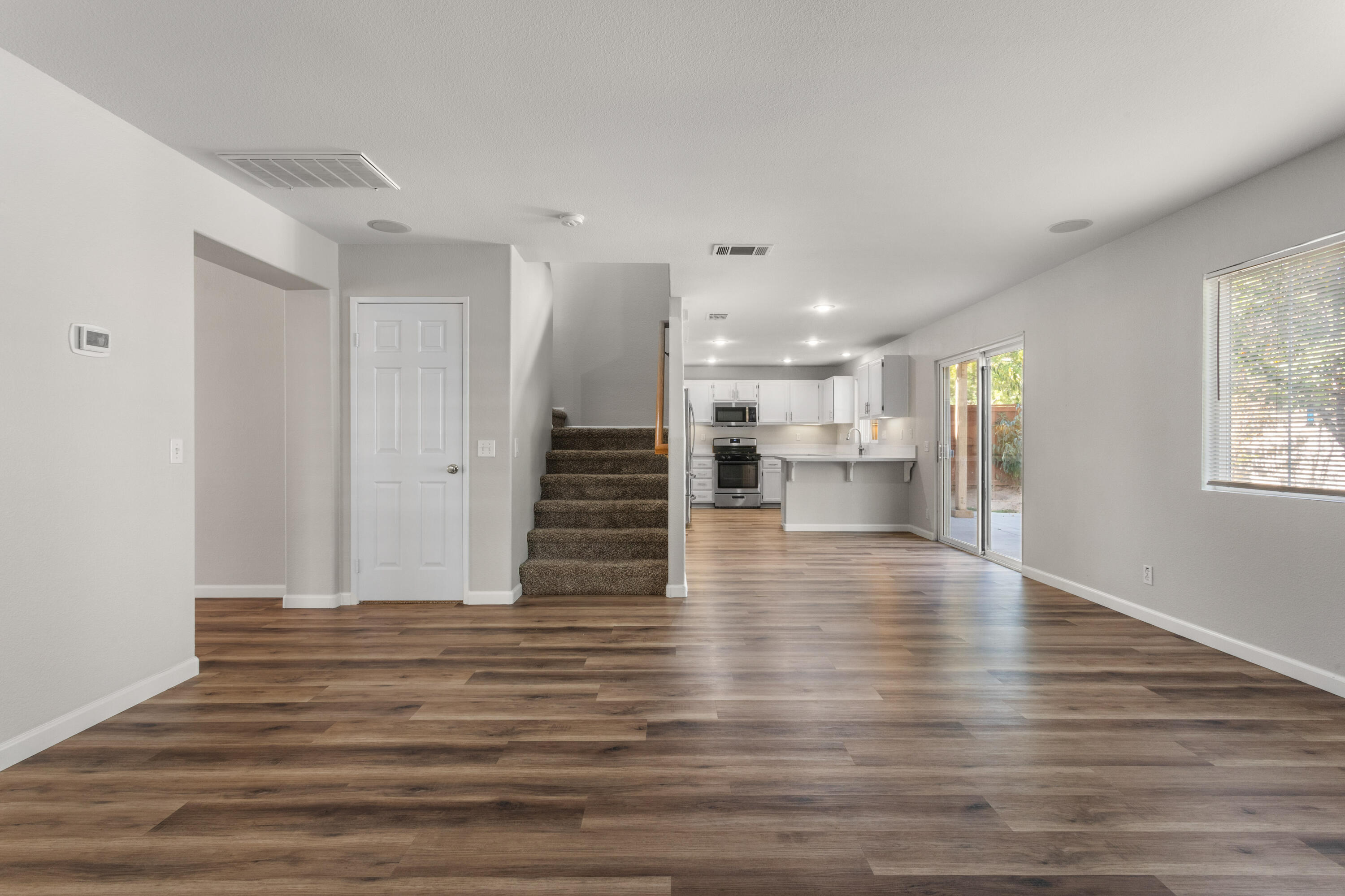 41970 Pacific Grove Way Temecula, CA 92591 - Photo 10 of 54 a view of a living room with wooden floor and a kitchen