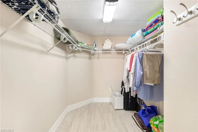 a view of walk in closet with clothes and shoes