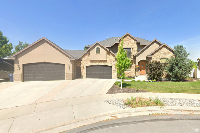 Stately stucco and stone exterior with multiple gables and a two-car garage