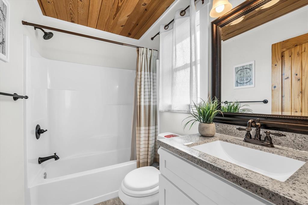 348 Barker Lane Waco, TX 76705 - Photo 25 of 39 a bathroom with a granite countertop sink a toilet a mirror and shower