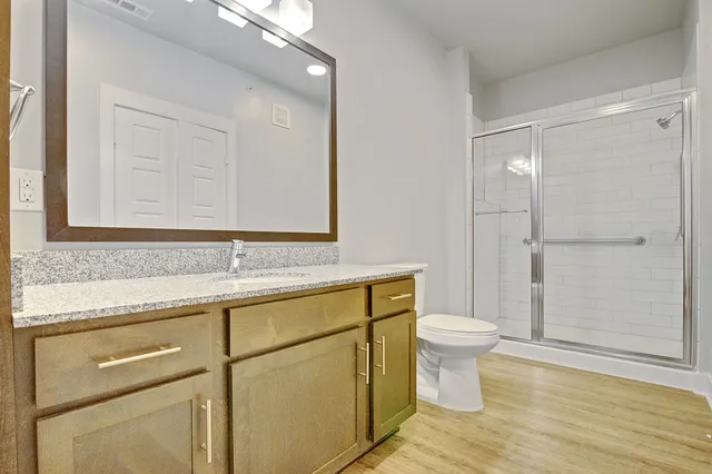 a bathroom with a sink a toilet and shower