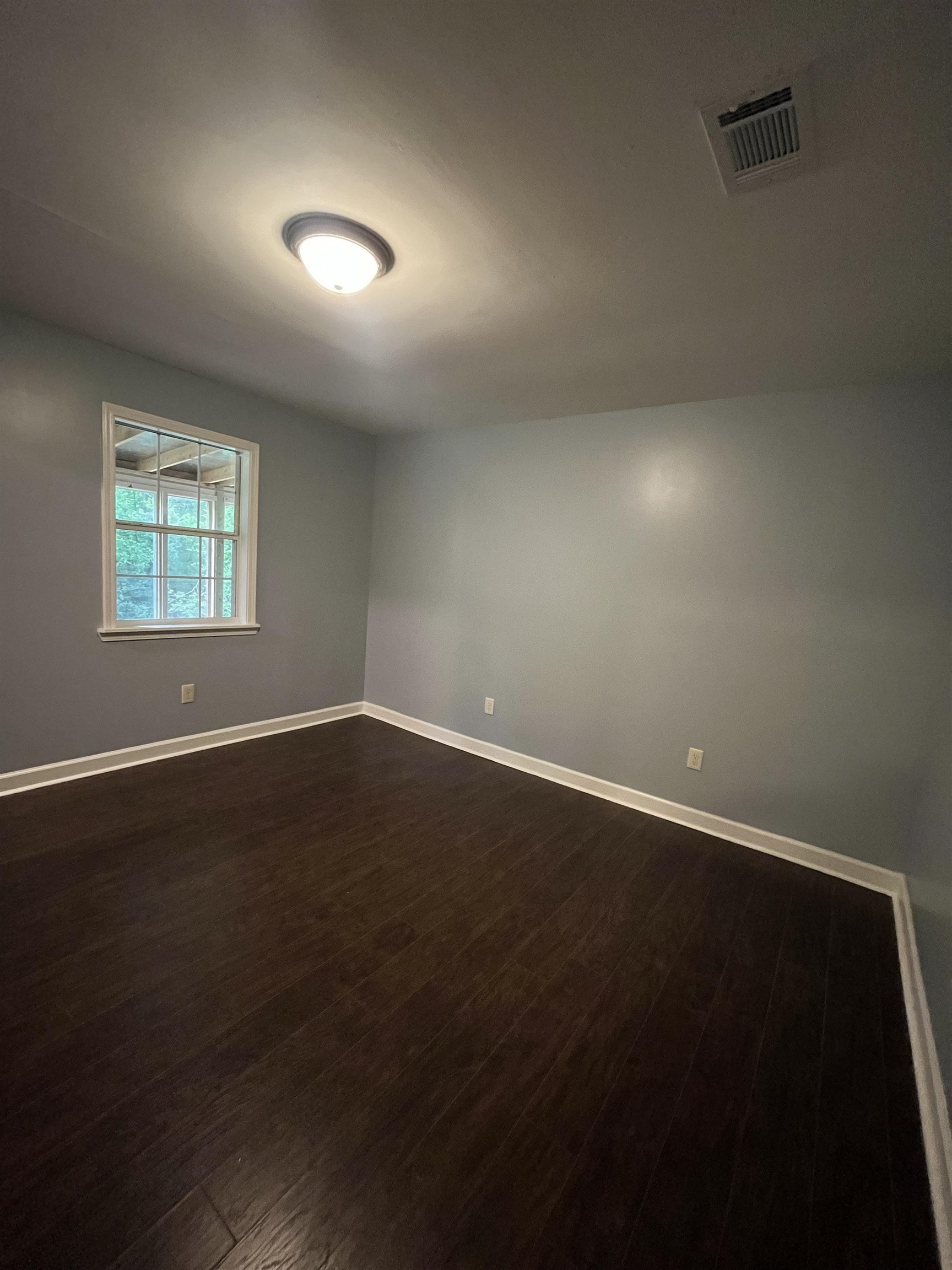 1204 Margaret Road Memphis, TN 38109 - Photo 13 of 25 an empty room with wooden floor and windows