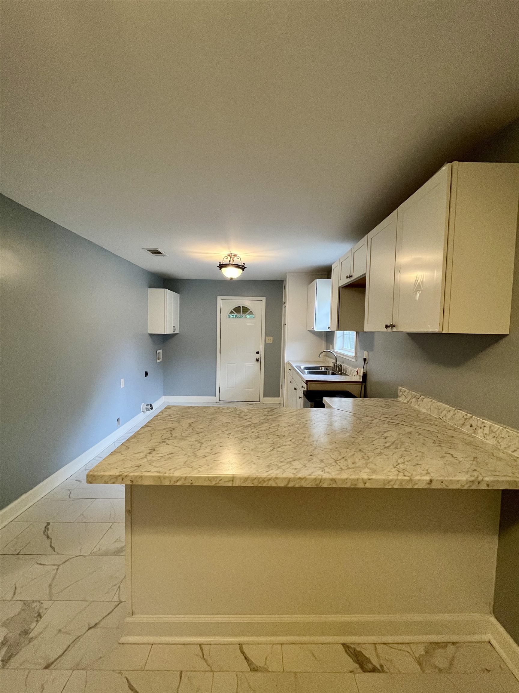 1204 Margaret Road Memphis, TN 38109 - Photo 6 of 25 a bathroom with a granite countertop sink and white cabinets