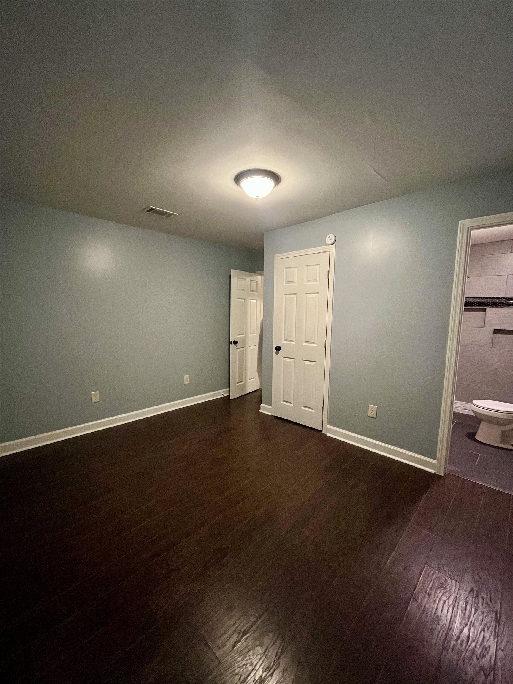 1204 Margaret Road Memphis, TN 38109 - Photo 9 of 25 an empty room with wooden floor and windows