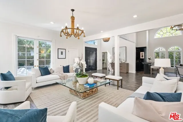 a living room with furniture dining area and a chandelier