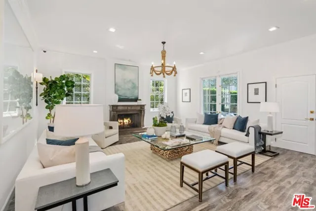 a living room with fireplace furniture and a chandelier