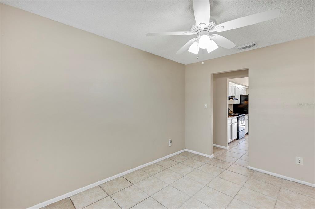 6701 Merlin Court Orlando, FL 32810 - Photo 12 of 54 wooden floor in an empty room with a chandelier