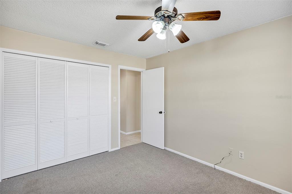 6701 Merlin Court Orlando, FL 32810 - Photo 22 of 54 an empty room with a chandelier fan