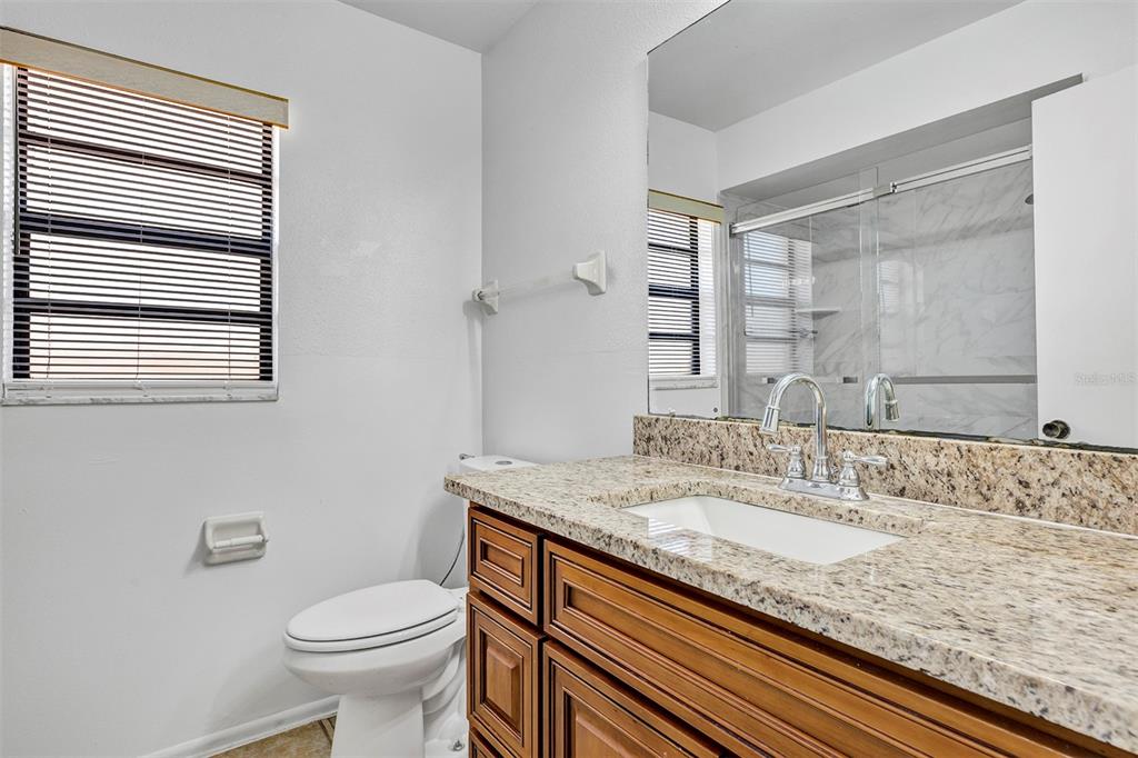 6701 Merlin Court Orlando, FL 32810 - Photo 23 of 54 a bathroom with a granite countertop sink toilet and shower