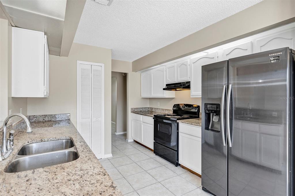 6701 Merlin Court Orlando, FL 32810 - Photo 28 of 54 a kitchen with stainless steel appliances granite countertop a sink stove and refrigerator