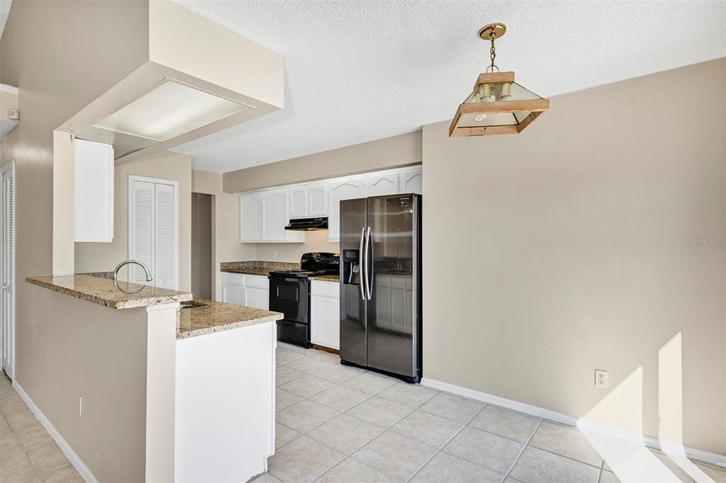 6701 Merlin Court Orlando, FL 32810 - Photo 30 of 54 a kitchen with refrigerator and cabinets