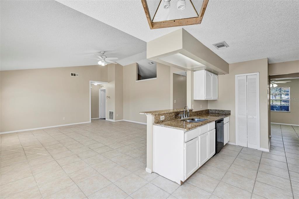 6701 Merlin Court Orlando, FL 32810 - Photo 31 of 54 a kitchen with granite countertop a stove and a sink