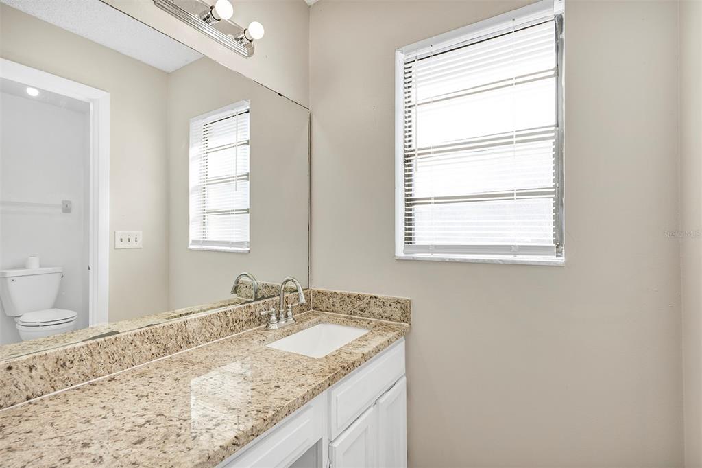 6701 Merlin Court Orlando, FL 32810 - Photo 41 of 54 a bathroom with a granite countertop sink and a window