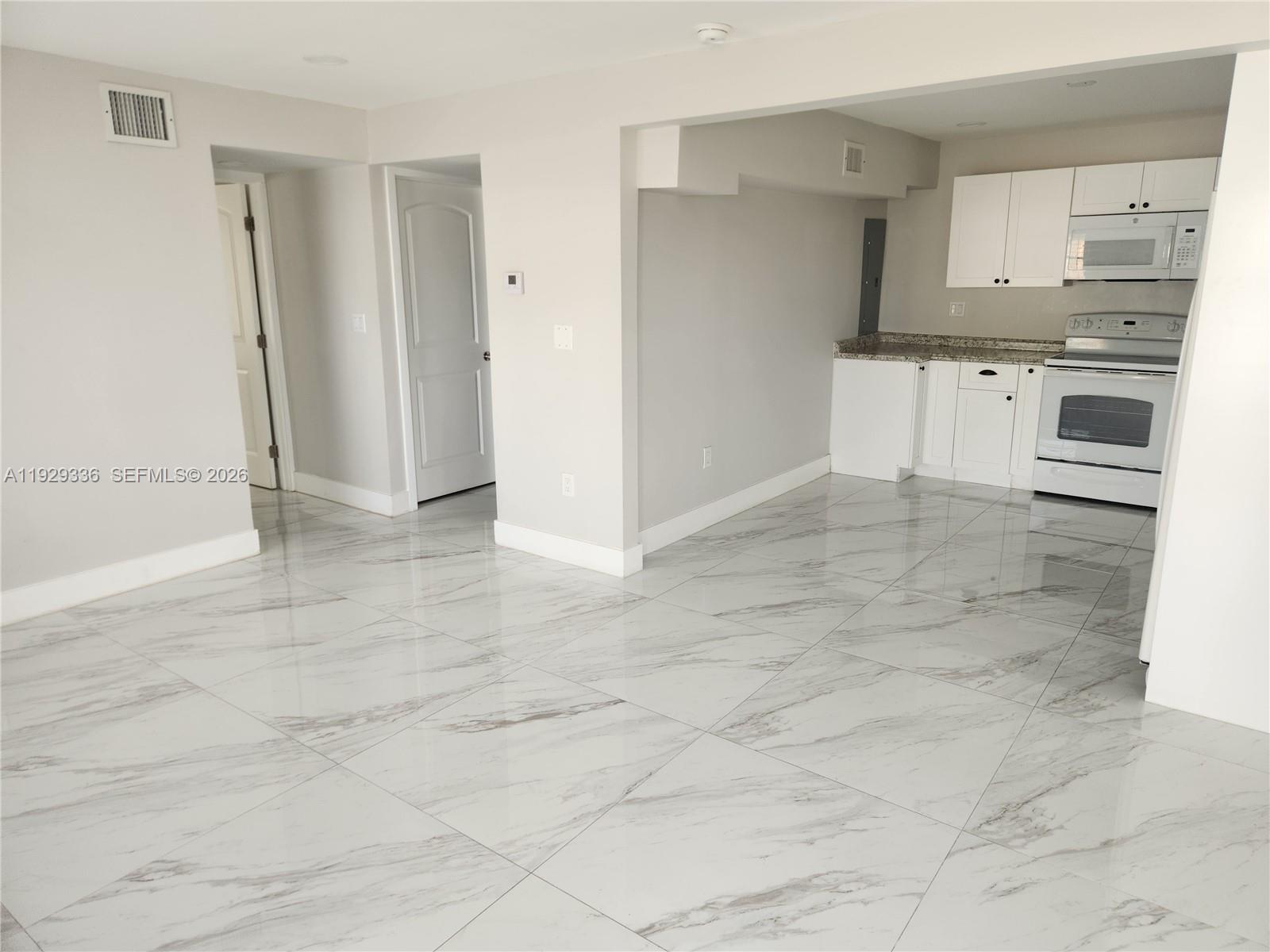 342 East 46th Street, Unit 1 Hialeah, FL 33013 - Photo 3 of 26 an empty room with kitchen view and a window