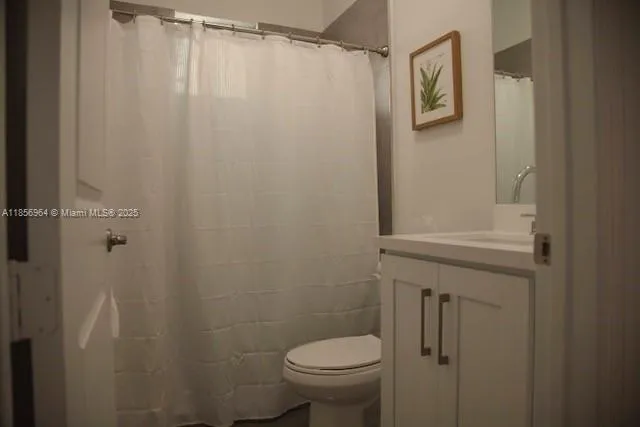 a bathroom with a shower curtain and a toilet