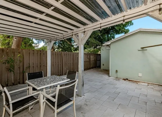 a view of a backyard with table and chairs with wooden floor and fence