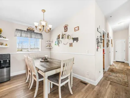a kitchen with stainless steel appliances granite countertop a sink dishwasher and a refrigerator with wooden floor