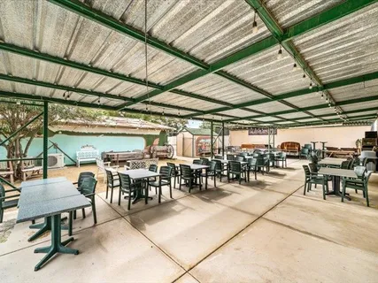 a view of a house with backyard and sitting area