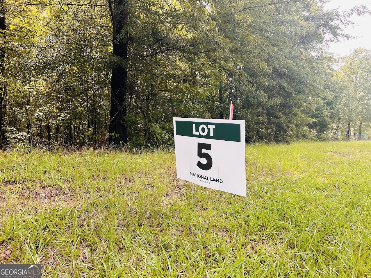 a sign that is sitting in front of a tree