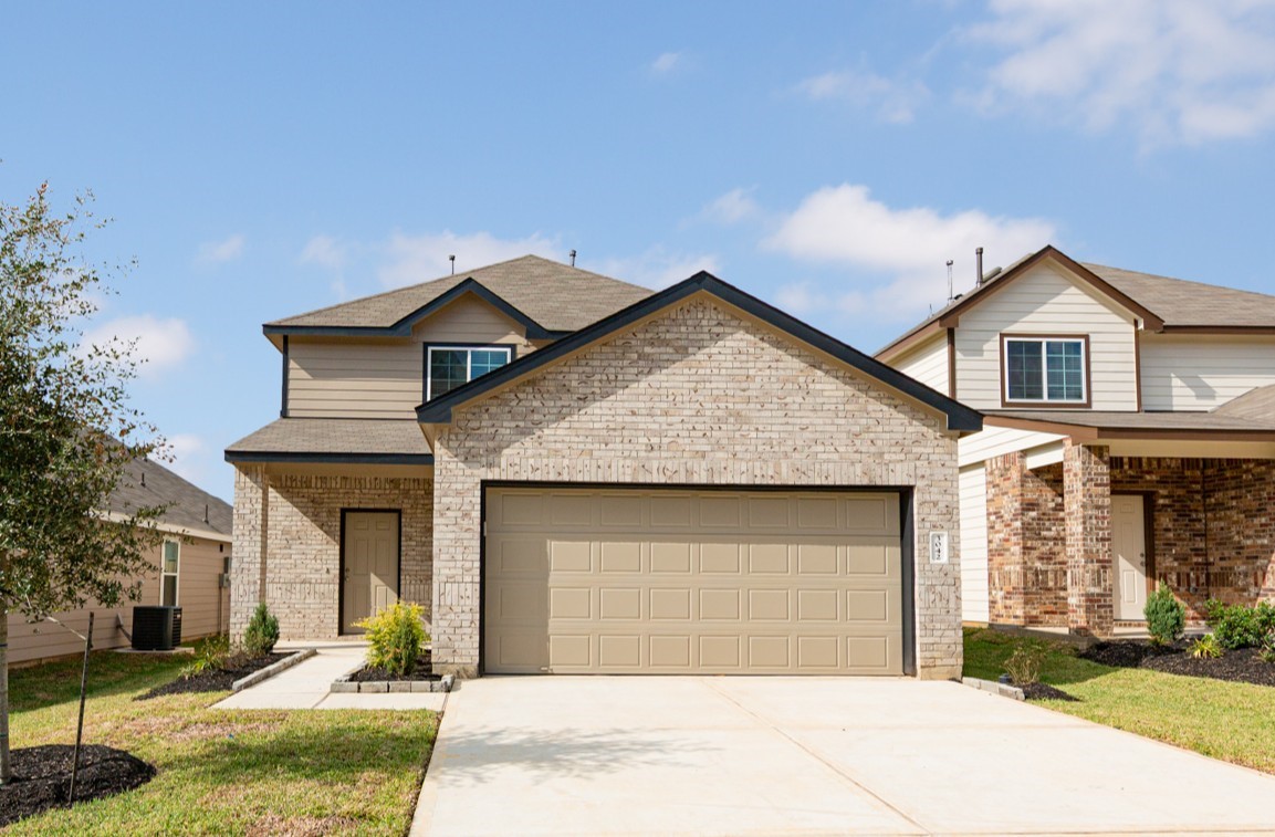 a front view of a house with a yard and garage