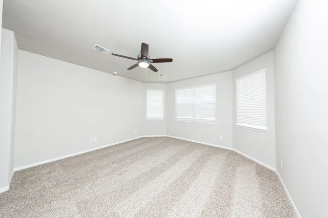 a view of a big room with wooden floor and windows