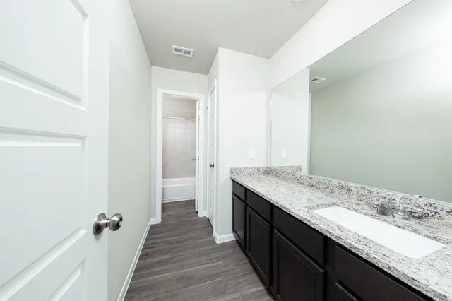a bathroom with a granite countertop sink and a mirror