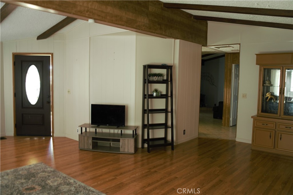 58870 Granite Gulley Road Anza, CA 92539 - Photo 10 of 29 a view of a livingroom with wooden floor and a flat screen tv