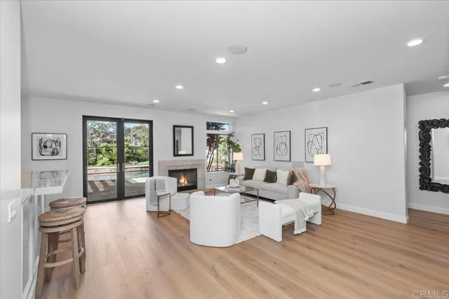 a living room with furniture kitchen view and a chandelier