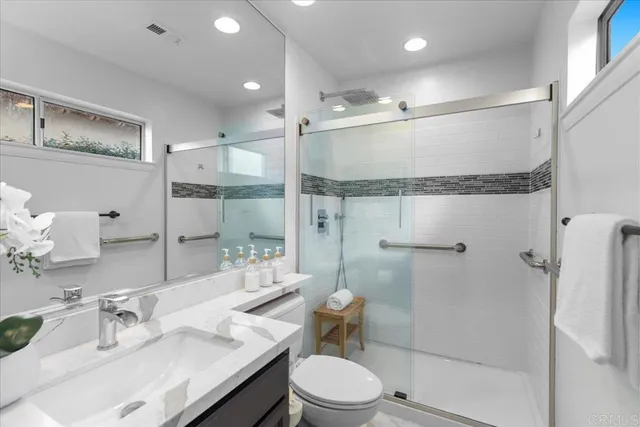 a bathroom with a sink mirror and a shower