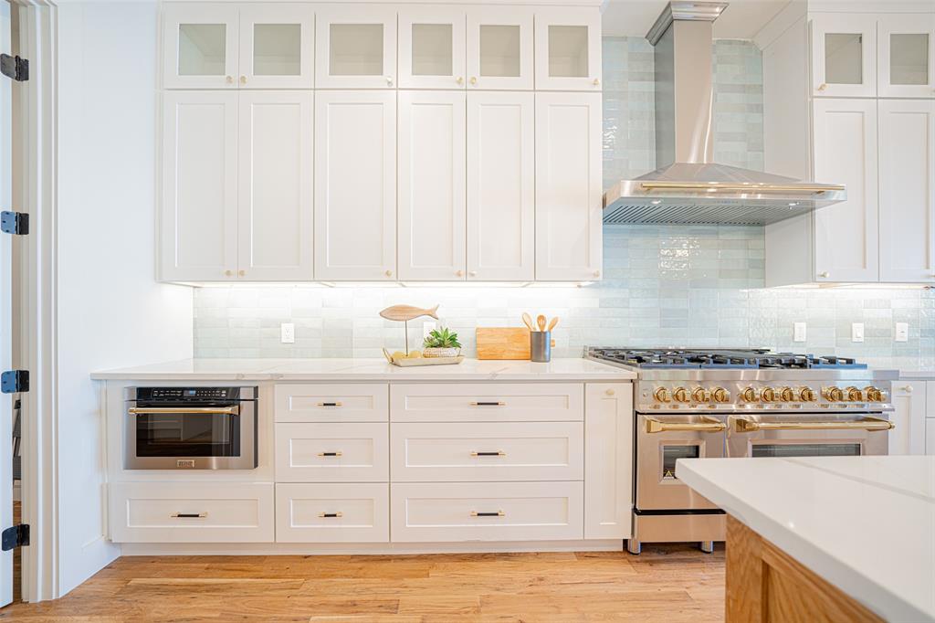 a kitchen with stainless steel appliances granite countertop a stove a sink and a microwave