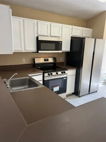 a kitchen with stainless steel appliances a refrigerator a stove a microwave and cabinets