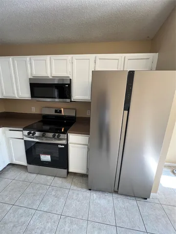 a kitchen with stainless steel appliances a refrigerator a stove a microwave and a sink