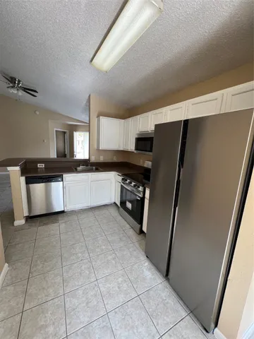 a large kitchen with a stove a refrigerator and a sink